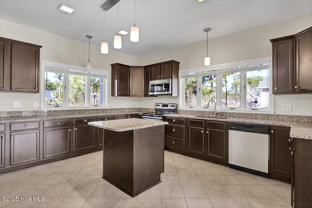 kitchen featuring stainless steel appliances, a healthy amount of sunlight, sink, and decorative light fixtures