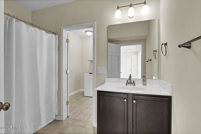 bathroom featuring vanity, washer / dryer, and tile patterned floors