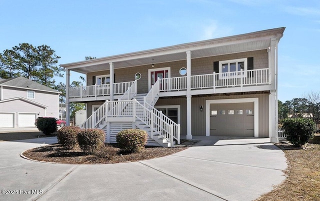 raised beach house featuring a garage and a porch