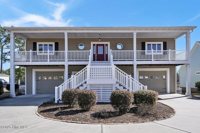 coastal inspired home with a porch and a garage