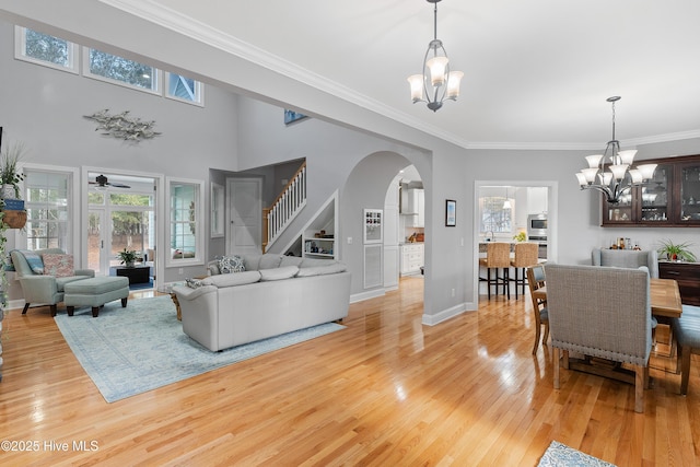 living area with light wood-style floors, plenty of natural light, and an inviting chandelier