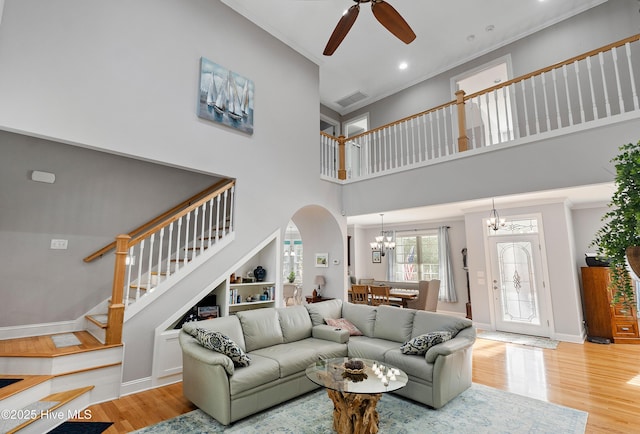 living room featuring stairs, ornamental molding, wood finished floors, and visible vents