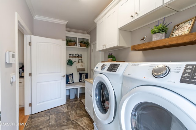 laundry room with ornamental molding, cabinet space, and separate washer and dryer