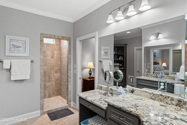 bathroom featuring ornamental molding, vanity, baseboards, and ensuite bathroom