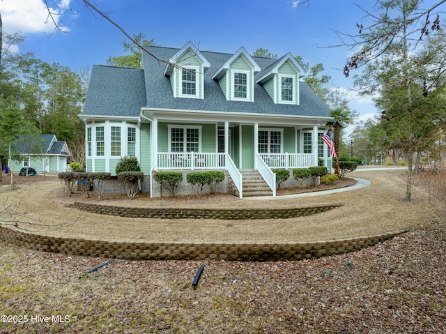 cape cod-style house featuring a shingled roof and a porch