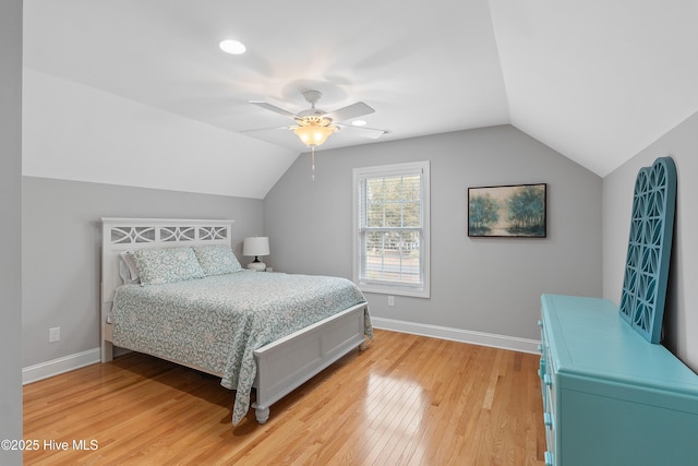 bedroom with baseboards, vaulted ceiling, and wood finished floors