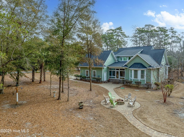 view of front of home featuring driveway, an outdoor fire pit, and a patio