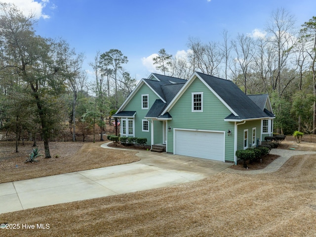 view of front facade with a shingled roof, driveway, and a garage