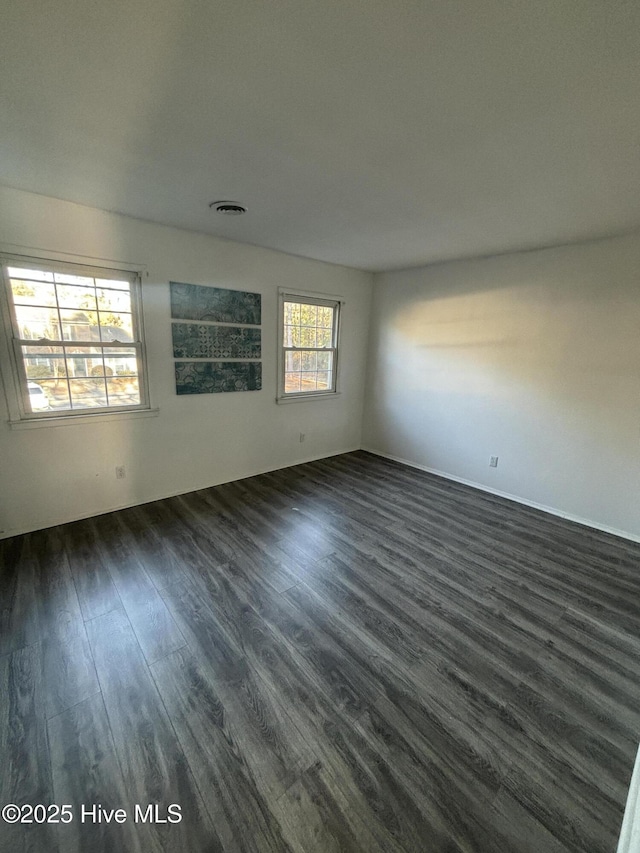 spare room featuring dark wood-type flooring