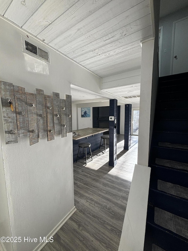 corridor with wood-type flooring and wooden ceiling