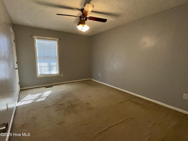 empty room with ceiling fan, carpet flooring, and a textured ceiling