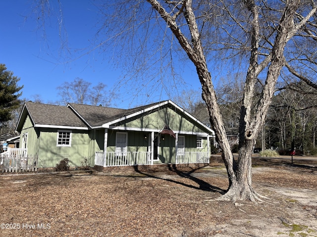 view of front of house featuring covered porch and a shingled roof