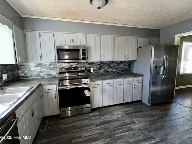 kitchen with sink, white cabinetry, tasteful backsplash, appliances with stainless steel finishes, and dark hardwood / wood-style flooring