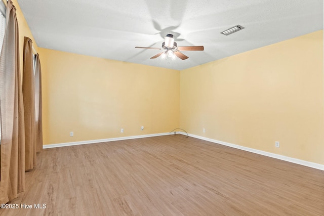 unfurnished room with ceiling fan, light hardwood / wood-style flooring, and a textured ceiling