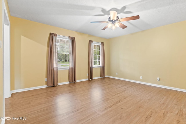 empty room featuring ceiling fan, a textured ceiling, and light wood-type flooring