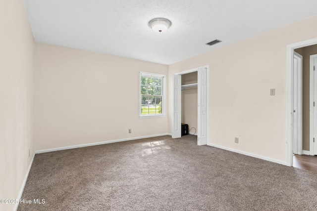 unfurnished bedroom with carpet floors, a closet, and a textured ceiling