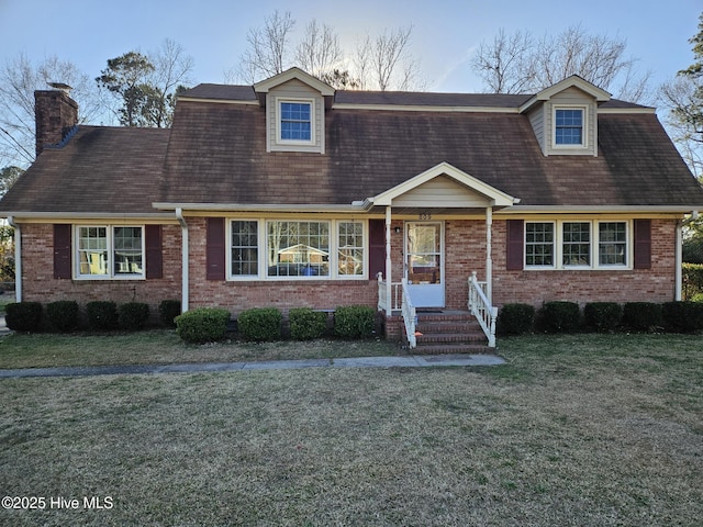 cape cod house with a front yard