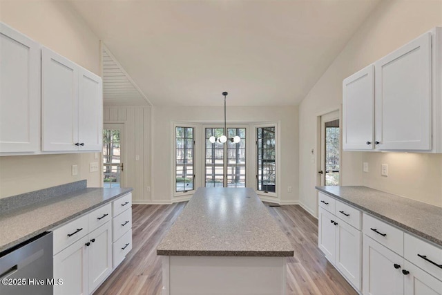 kitchen with light wood-style floors, a kitchen island, white cabinets, and stainless steel dishwasher