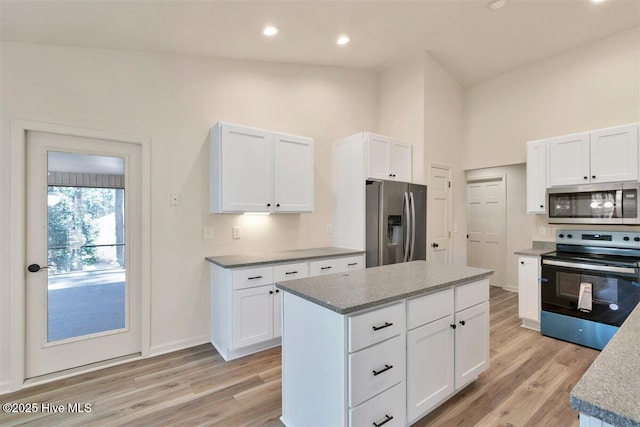 kitchen with white cabinets, light wood finished floors, and stainless steel appliances