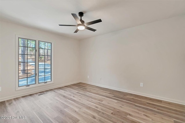 unfurnished room featuring baseboards, a ceiling fan, visible vents, and light wood-style floors