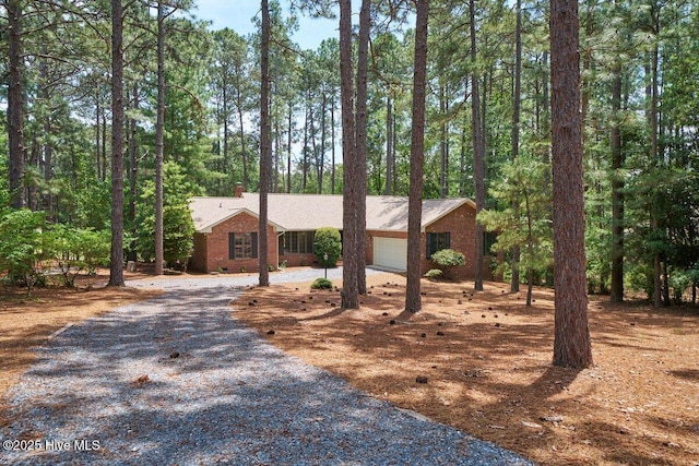 111 Forest Square Ln, West End, NC 27376 - view of front of house with driveway, a garage, a chimney, and brick siding