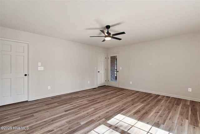 spare room with ceiling fan, baseboards, and wood finished floors