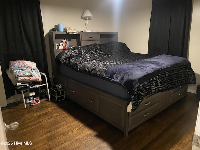 bedroom with dark wood-type flooring