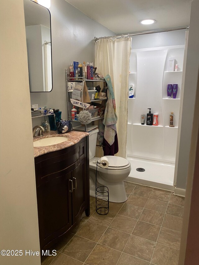 bathroom featuring vanity, toilet, and curtained shower