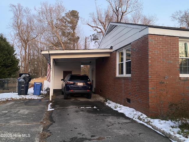 view of snowy exterior featuring a carport