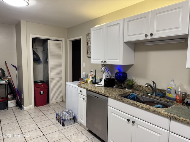 kitchen with stainless steel dishwasher, dark stone counters, sink, and white cabinets