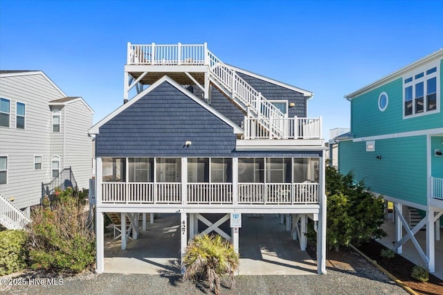 back of property featuring a carport and a sunroom