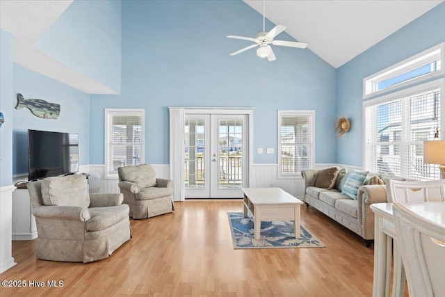 living room with a wealth of natural light, light hardwood / wood-style floors, and french doors