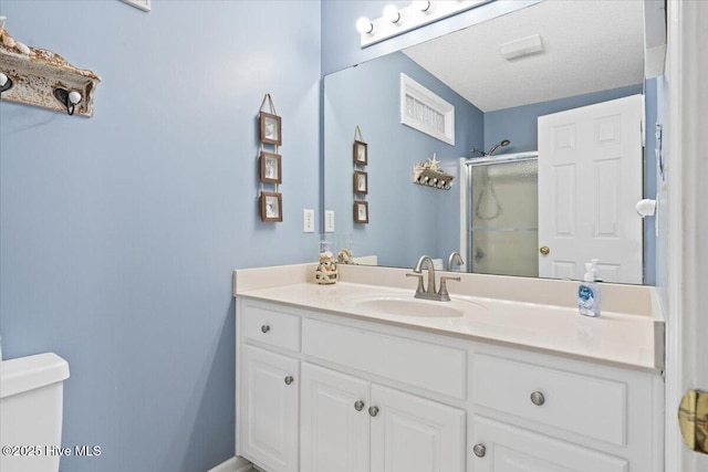 bathroom with vanity, toilet, and a shower with shower door