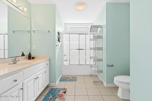 bathroom featuring a shower with door, vanity, tile patterned flooring, and toilet