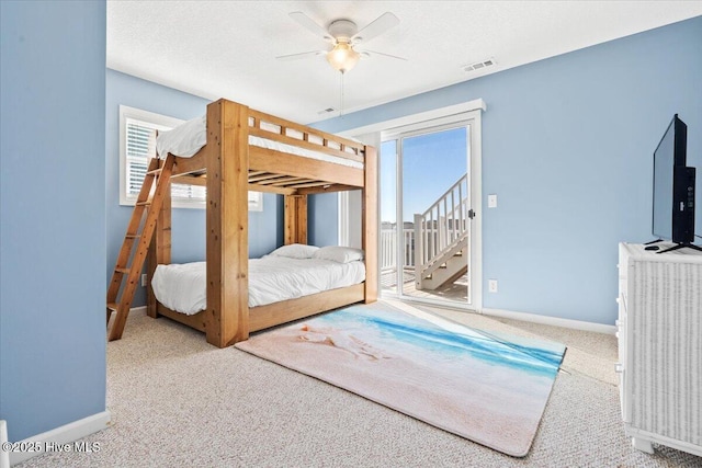 bedroom with ceiling fan, access to exterior, carpet floors, and a textured ceiling