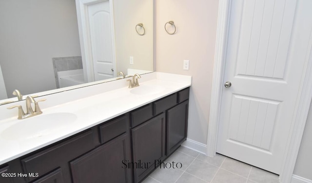 bathroom with vanity, a washtub, and tile patterned floors