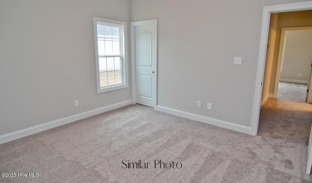 unfurnished room featuring light colored carpet