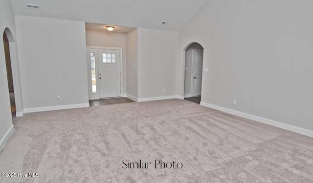 interior space with light colored carpet and vaulted ceiling