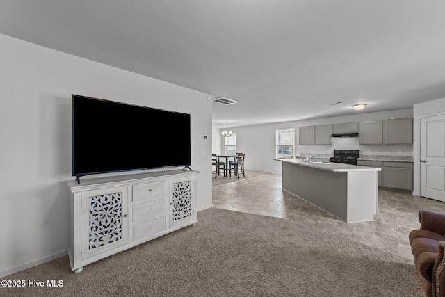 living room featuring sink, light carpet, and an inviting chandelier