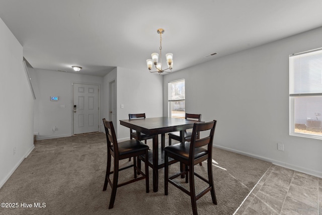 carpeted dining area with an inviting chandelier