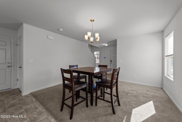 carpeted dining area with an inviting chandelier