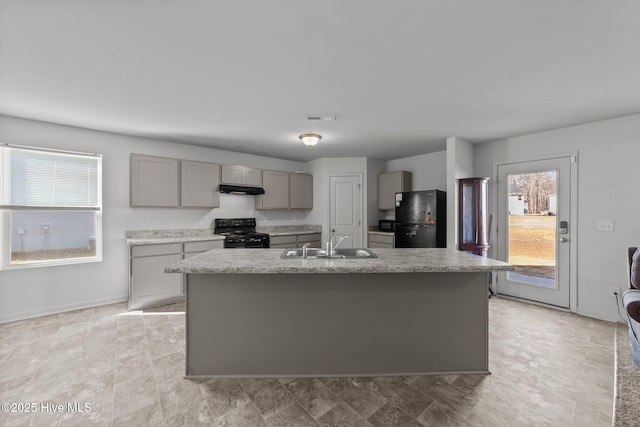 kitchen featuring gray cabinets, sink, black appliances, and a center island with sink