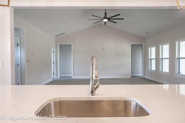 kitchen featuring sink, vaulted ceiling, light stone countertops, and ceiling fan