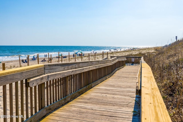 surrounding community featuring a water view and a beach view