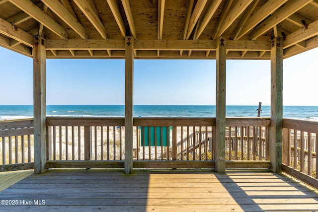 wooden terrace with a view of the beach and a water view