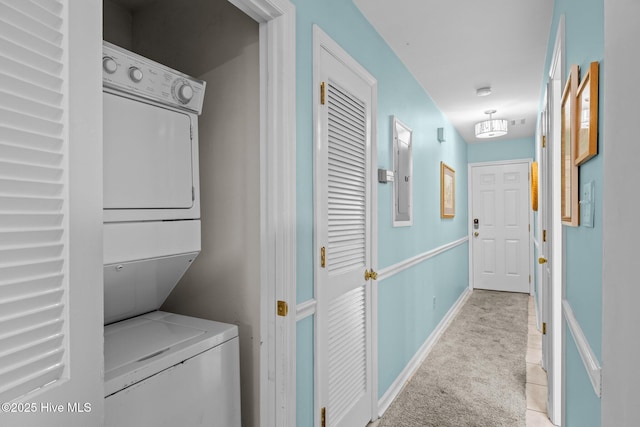 laundry room with light carpet and stacked washer / drying machine