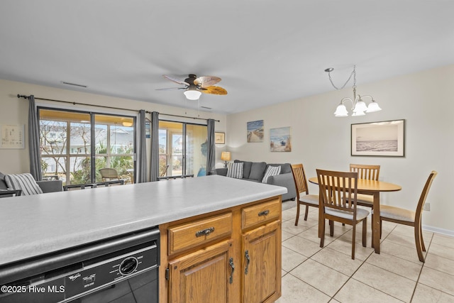 kitchen featuring pendant lighting, dishwasher, ceiling fan with notable chandelier, and light tile patterned floors