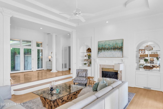 living area featuring recessed lighting, a high end fireplace, ceiling fan, and wood finished floors