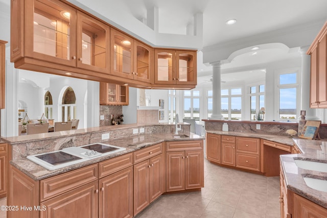 kitchen with light tile patterned floors, decorative backsplash, light stone counters, and white electric stovetop