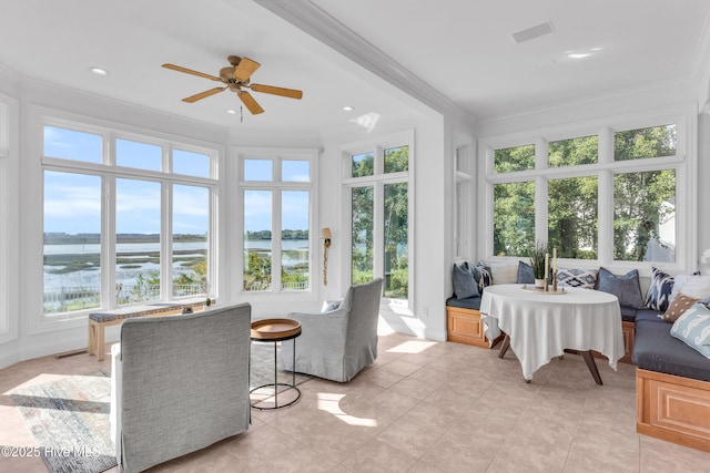 sunroom / solarium featuring plenty of natural light, a water view, tile patterned flooring, and ornamental molding